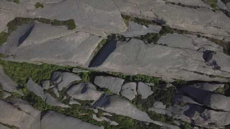 Drone stiger op, zoomer op i himlen med stenet kystterræn