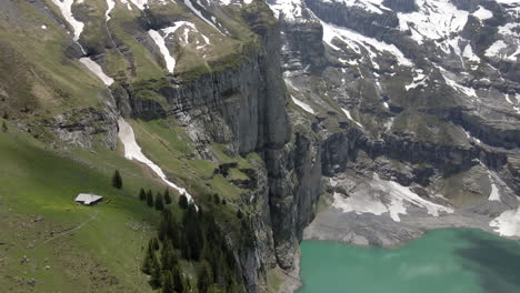 alm solitario sentado al borde de un acantilado con vistas al oeschinensee en suiza