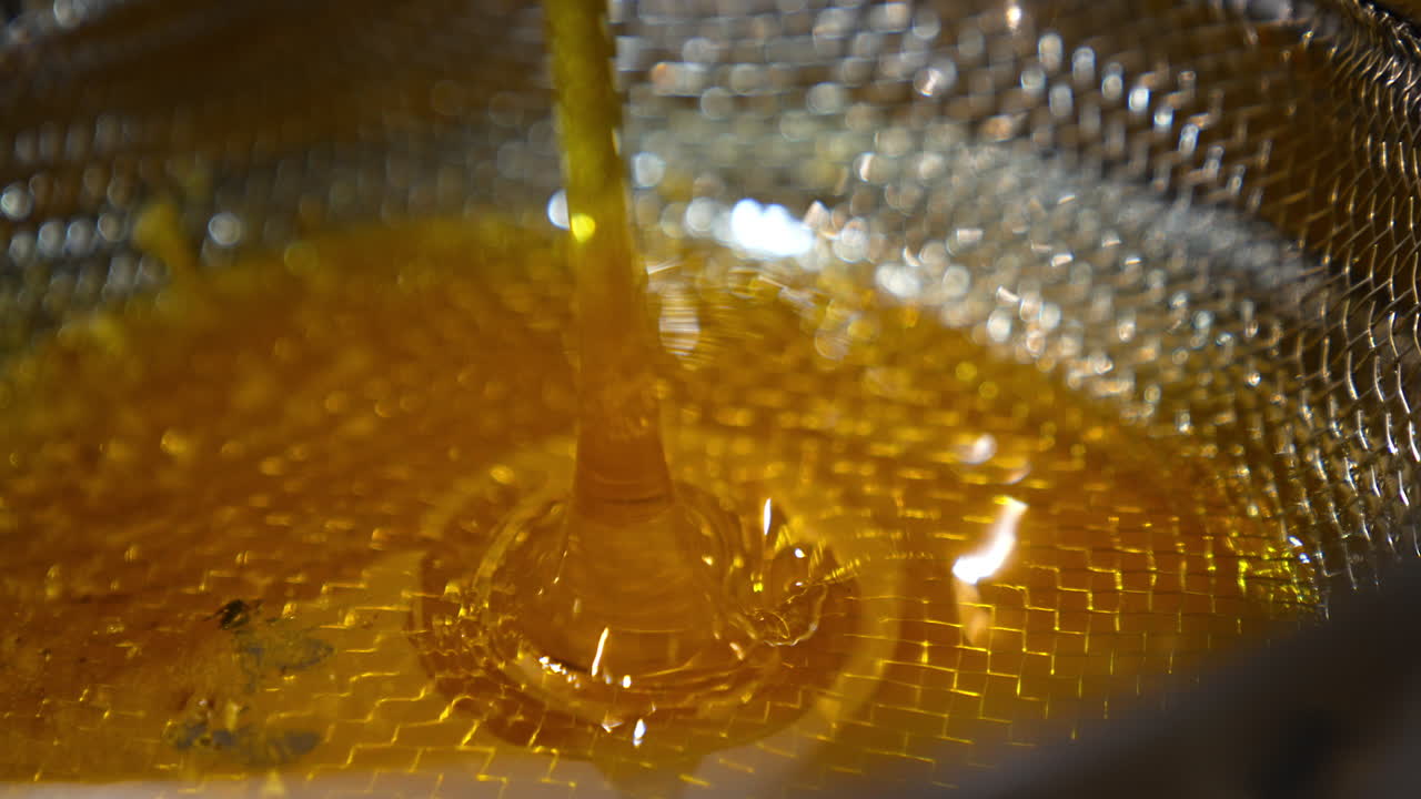 Miele che cola attraverso un colino