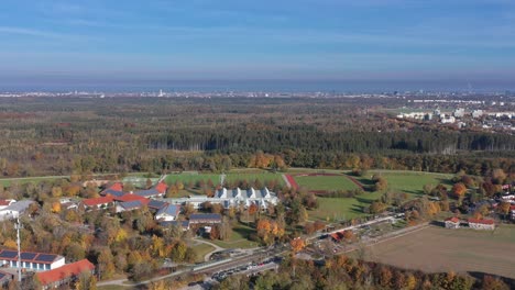 oncoming s-bahn trains filmed from a high angle view with the wide skyline of munich in the autumnal background