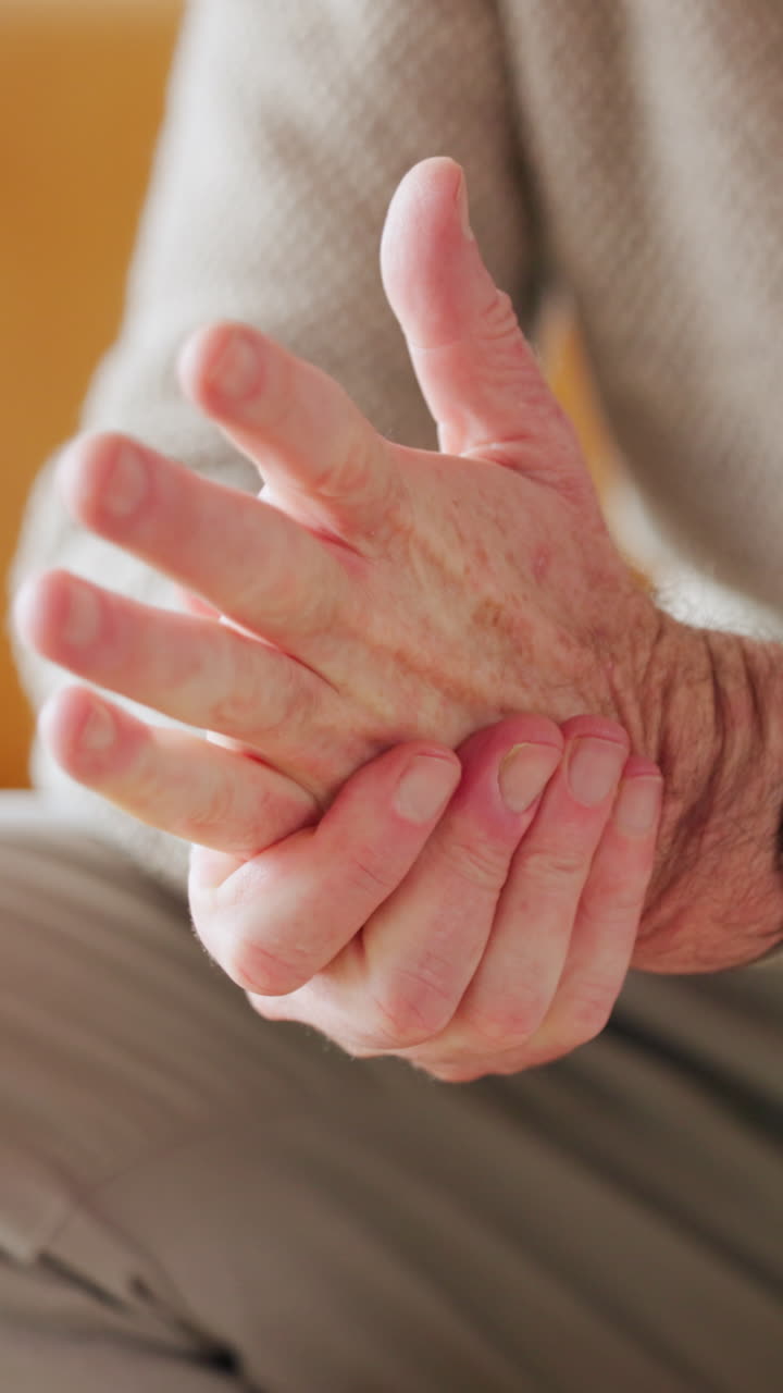 Primo piano di persona anziana che si massaggia le mani per alleviare il dolore articolare