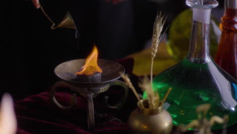 ritos góticos wiccanos: mujer química encendiendo una vela en medio de un humo enigmático - una romántica fotografía cinematográfica pre-rafaelita