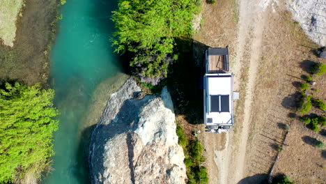 Overhead-Auszoomen-Expeditionslastwagen-überlandet-Fluss,-Blaues-Wasser,-Vegetation-Entlang-Der-Strecke,-Lago-Posada,-Argentinien