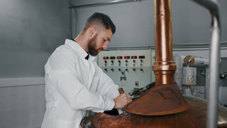 brewer working on a copper fermentation tank