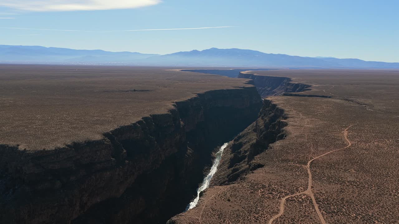 Ripresa aerea che segue il percorso sinuoso del Rio Grande mentre serpeggia tra le imponenti pareti rocciose erose del canyon nel sud-ovest americano