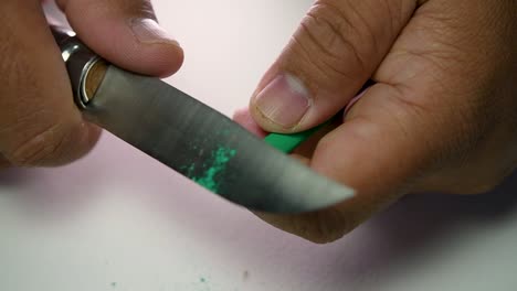 Footage-of-hands-slowly-sharpening-a-pencil-and-some-coloured-pencils-with-a-sharp-knife