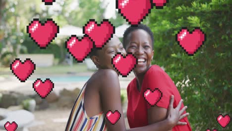 animación de corazones sobre sonrientes madre y hija afroamericanas en el jardín
