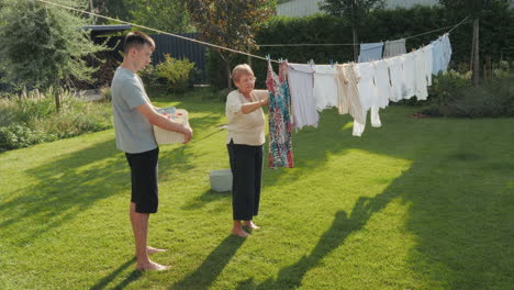 grandchild helping grandmother with laundry in the garden