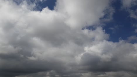 Blauer-Sommerhimmel-Mit-Dichten,-Dicken-Regenwolken,-Die-Sich-über-Den-Himmel-Bewegen