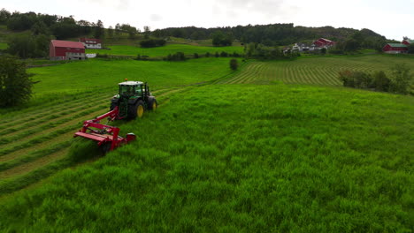 Farmer-in-tractor-is-mowing-field-with-grass-cutting-machine-on-green-field