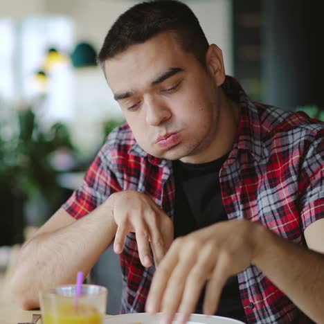 a young man is eating pizza and drinking juice in the cafe at lunch