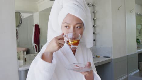 Happy-asian-woman-drinking-tea-in-bathroom,-in-slow-motion