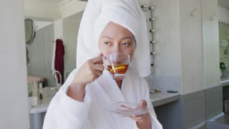 mujer asiática feliz bebiendo té en el baño, en cámara lenta