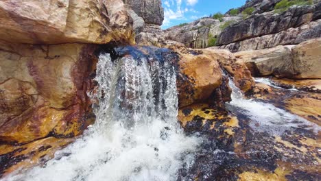 Pan-shot-of-a-small-stream-flowing-over-rocks