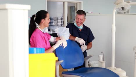 Equipo-De-Dentista-Sonriente-Charlando-Con-El-Asistente