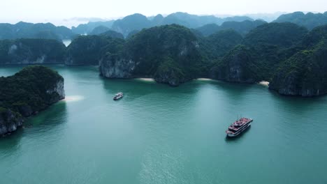 Ha-Long-Bay-Luftaufnahme:-Atemberaubende-Drohnenaufnahme-Von-Türkisfarbenem-Wasser,-Schiffen-Und-Majestätischen-Inseln