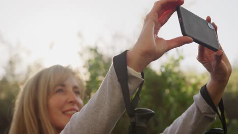 Mujer-Mayor-Activa-Tomando-Selfie-En-El-Bosque