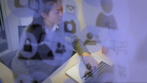 Animation-of-purple-icons-flying-over-a-woman-working-at-home