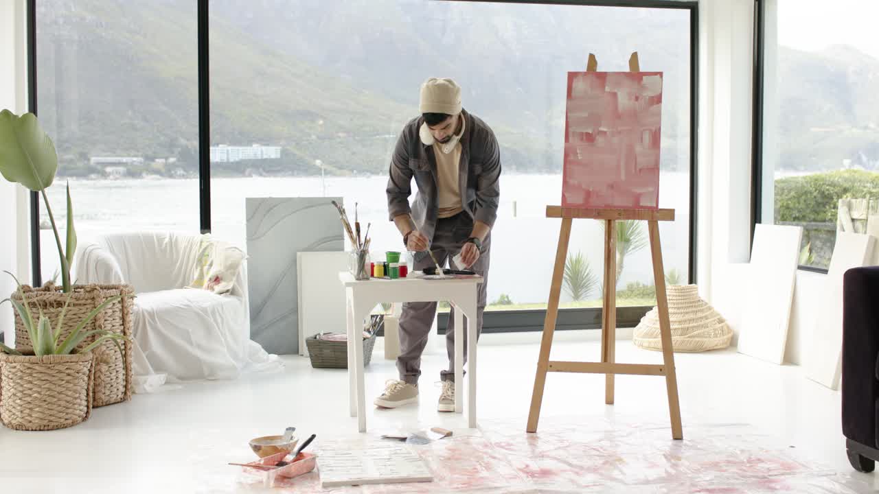 Dopo aver steso il foglio, l'artista sta miscelando i colori e testando le pennellate per rifinire il colore vicino alla vista del lago