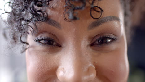 Close-up-of-a-young-biracial-woman-smiling-at-the-camera,-with-copy-space