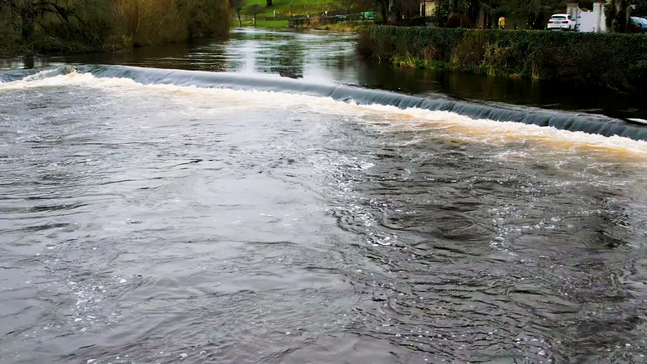 A 4K reveal of the fast flowing River Suir flowing through Cahir Town Centre Tipperary Ireland where many Hollywood films were set
