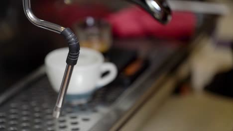 barista limpiando la máquina de café portafilter en la máquina de café por tron en el vapor y por la presión de flujo en la cafetería