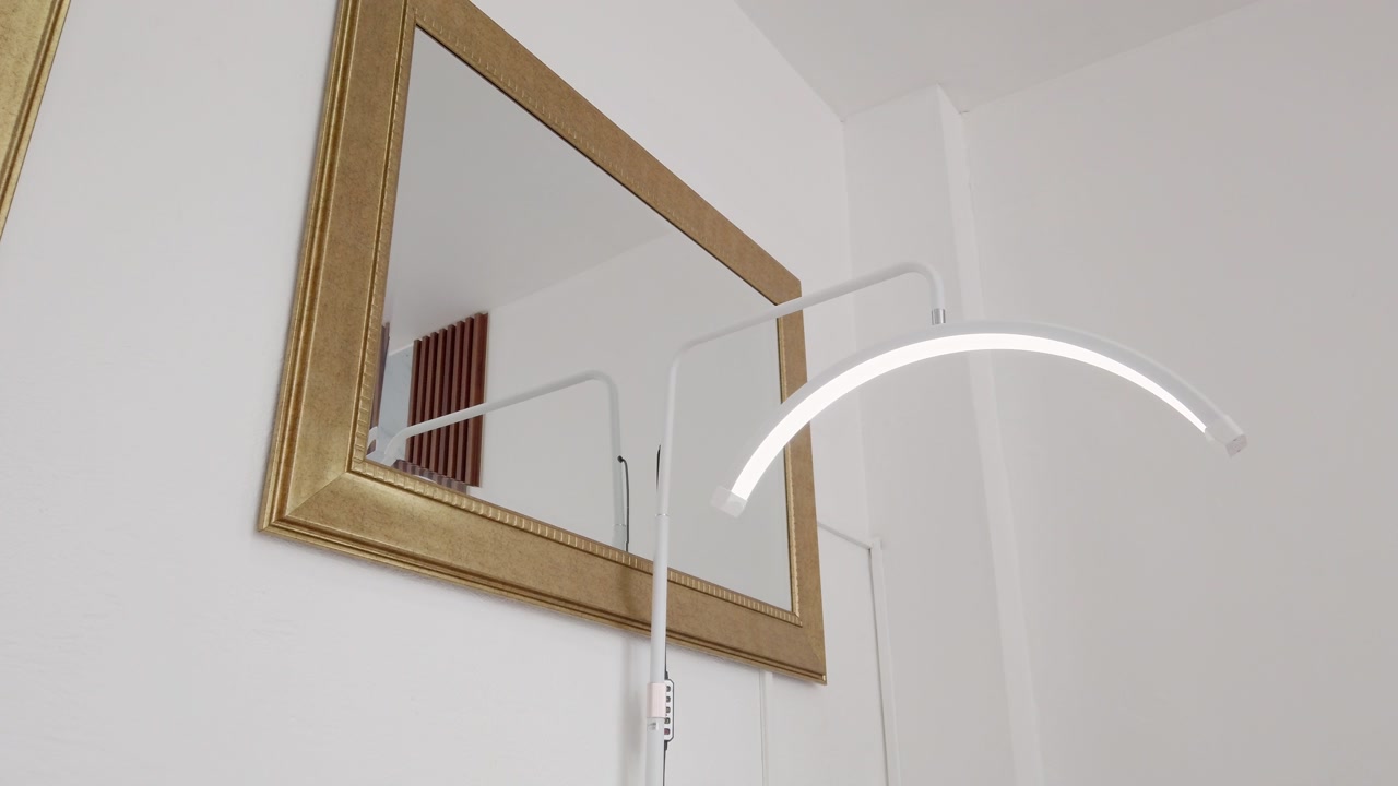 Elegant spa interior detail with golden framed mirror and white LED lamp for facial treatments