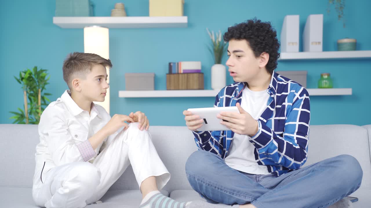 은 형제는 을 가지고 놀고 있는 남동생에게 화를 내고 있다.