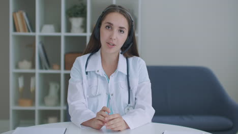 looking at the camera listening woman doctor looks at the camera and listens to the patient. a video conference listener. portrait of a doctor