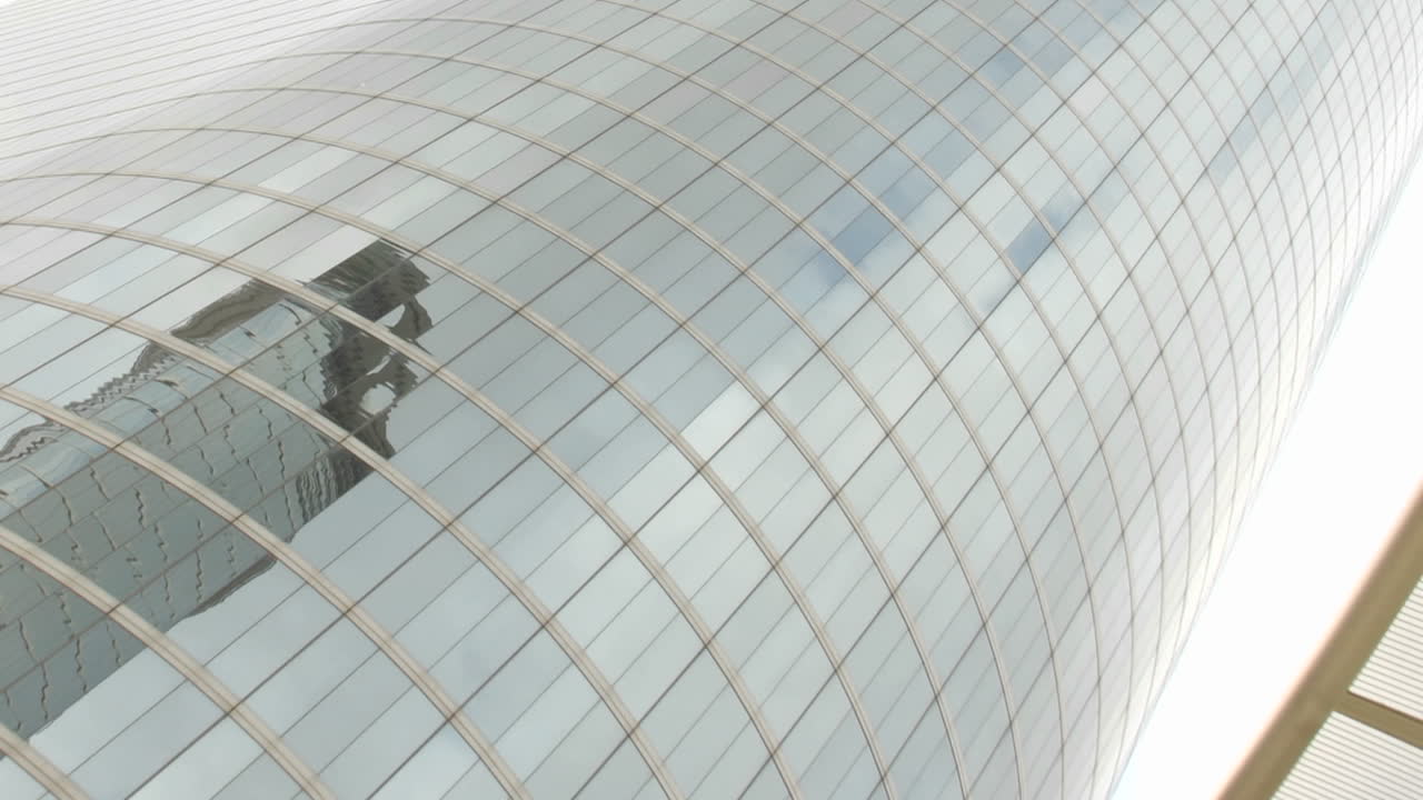 천천히 위로 움직이는 구름의 푸른 하늘과 주변 건물은 휴스턴 석유 회사 건물의 거울 벽을 반사했습니다.