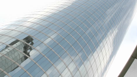 Slow-upward-pan-of-moving-clouds-blue-sky-and-surrounding-buildings-reflected-the-mirrored-walls-of-the-Houston-Oil-Company-building