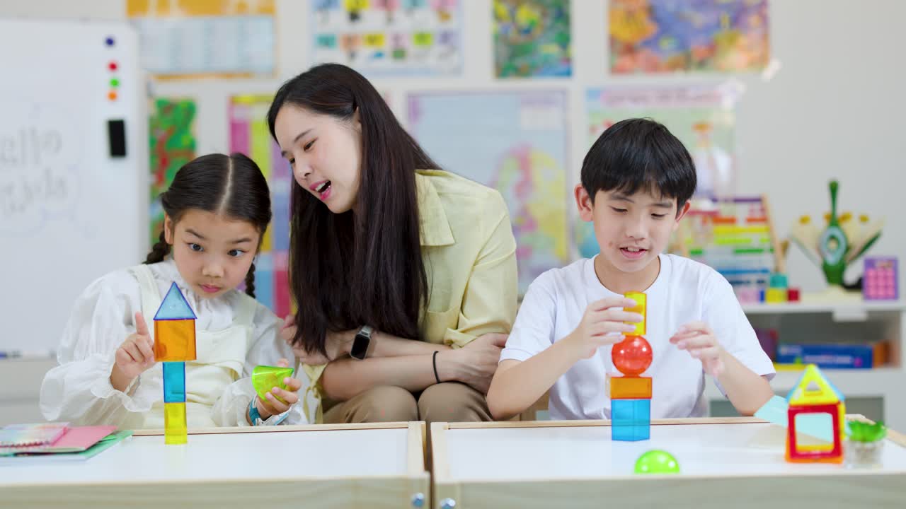 子供と先生が交流し、明るく自然光が差し込む教室でカラフルなブロックを組み立てています。