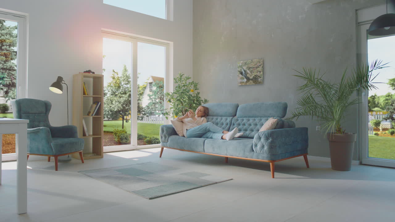 소파에서 휴식을 취하는 스마트폰을 사용하는 여성