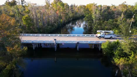 slow rise over water with utility truck driving across bridge in florida panhandle