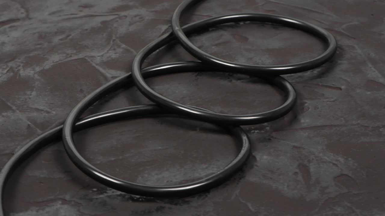 Black wire isolated on black and texture background. Side view. Loop motion. Rotation 360.