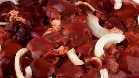 heap fresh raw chicken liver with raw onion, poultry liver, meat food. meal background.