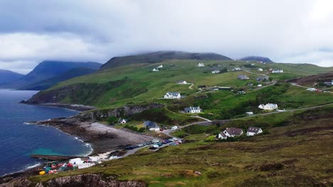 push-in drone shot of mountain harbour village by the ocean