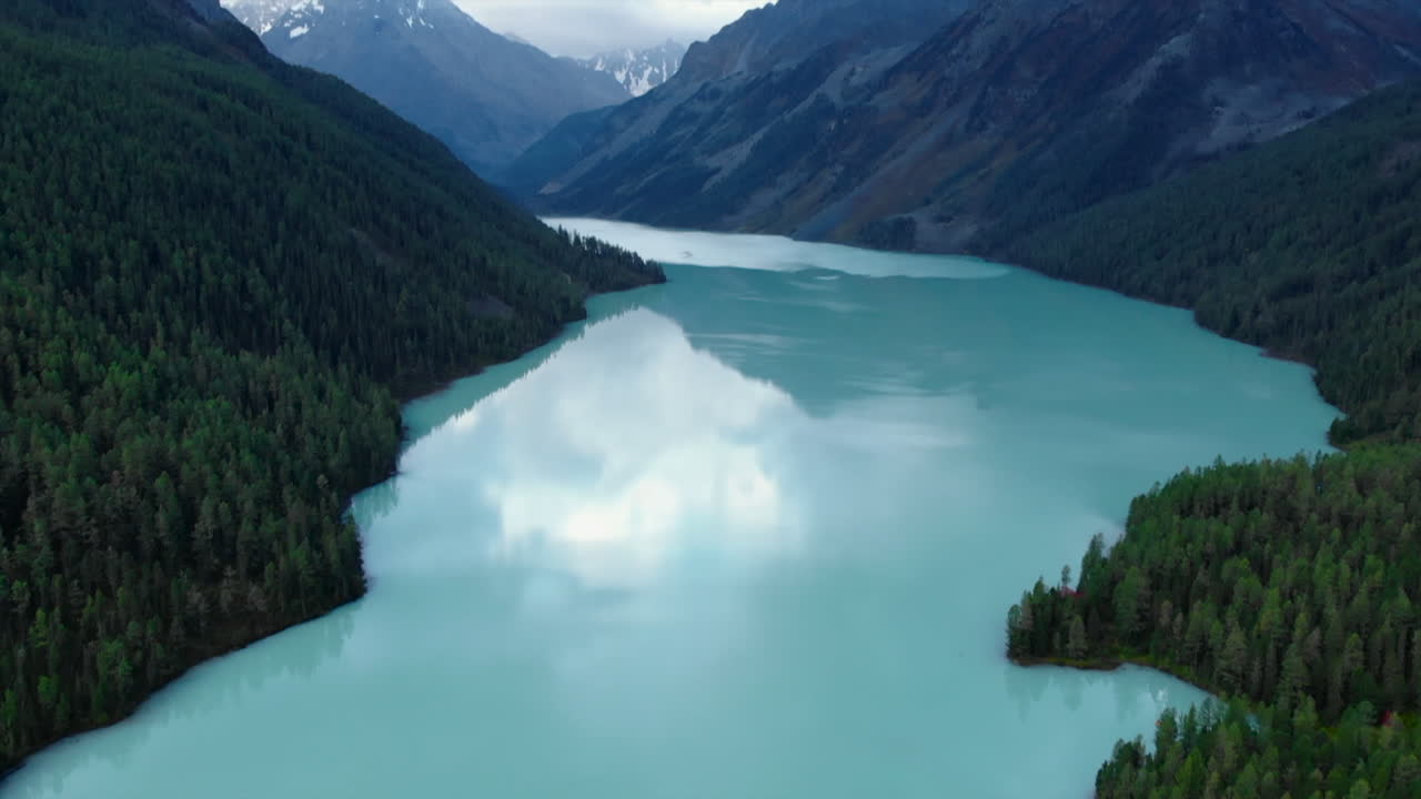 Aerial view of a lake surrounded by mountains and forest