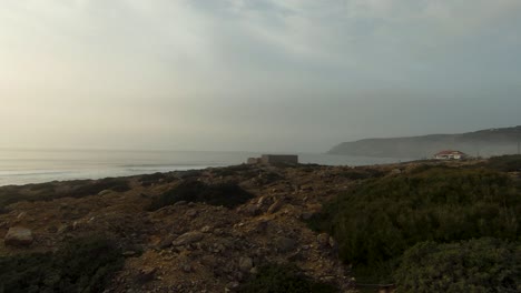 Close-up-of-a-drone-taking-off-in-the-middle-of-the-sand-with-the-sea-in-the-background-in-Guincho,-Cascais