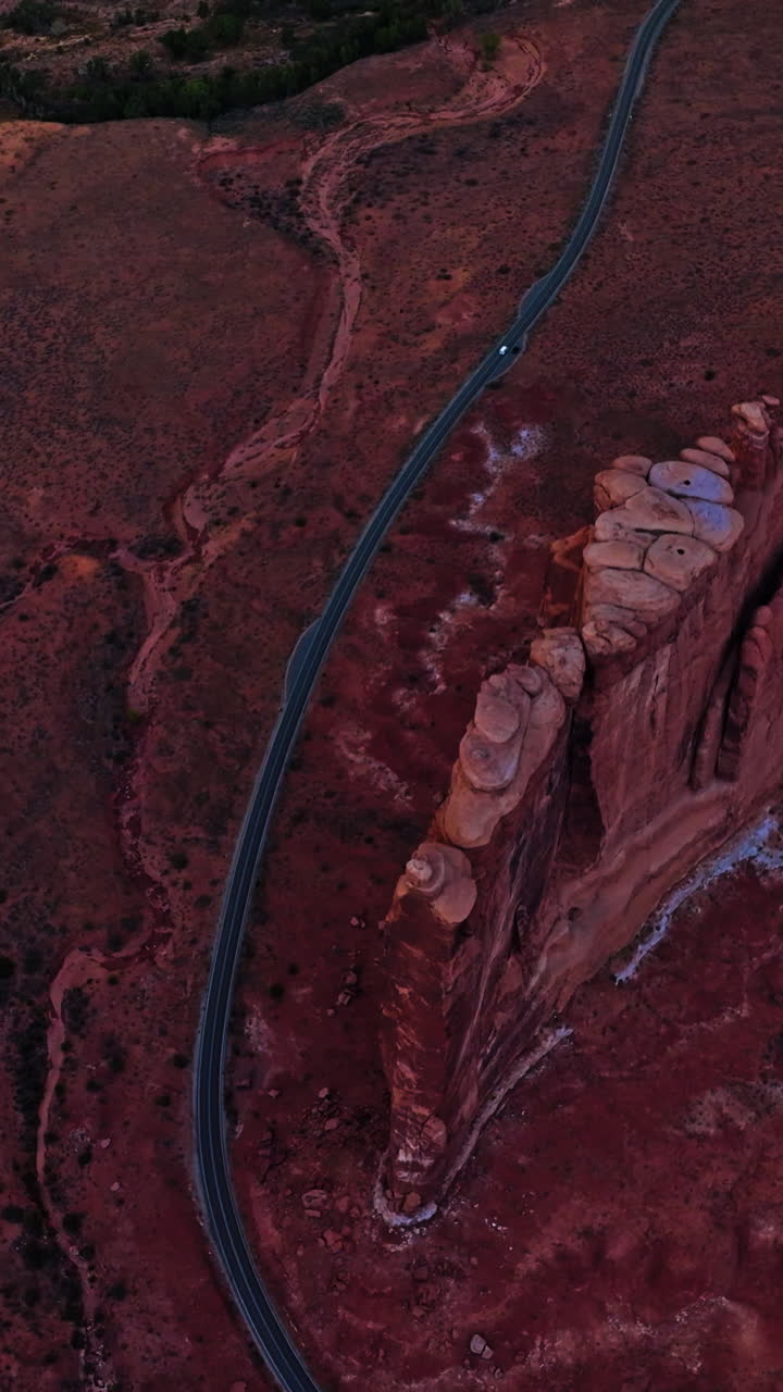 Long speed road going through a wild dessert landscape. Drone flying high above the plain in Zion canyon, Utah, USA. Vertical video