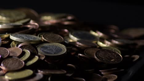 used coins of euro in a mountain turning in black background