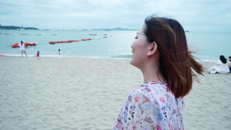 The-attractive-happy-young-woman-is-smiling-while-standing-near-the-beach-at-sunset-time