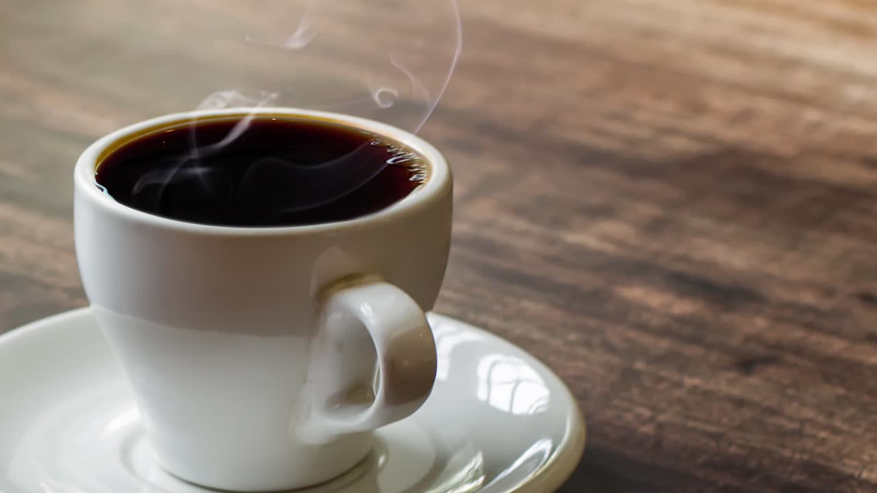 Un vaso de café por la mañana con humo.