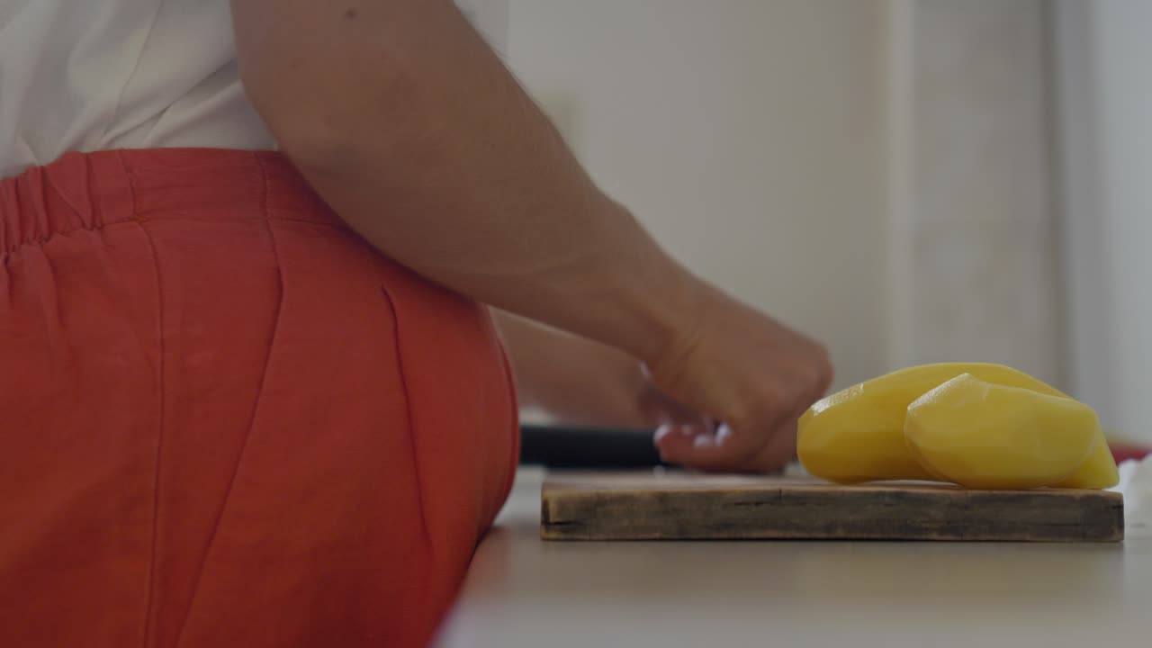감자를 들고 절단 보드를 고 있는 여자의 근접 사진