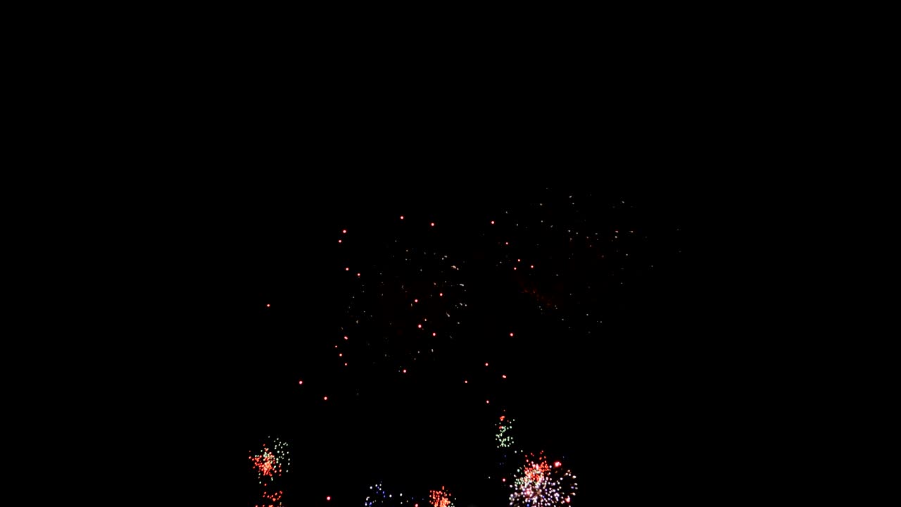 Fuochi d'artificio celebrativi che esplodono e brillano su sfondo scuro con effetto scuro e granuloso