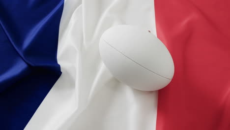 pelota de rugby blanca sobre la bandera de francia con espacio de copia, en cámara lenta