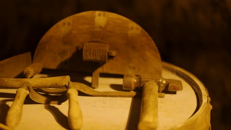 wooden mallet striking oak whiskey cask lid with traditional tools in rustic distillery workshop