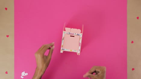 gluing together colorful paper cutouts for valentines day decoration