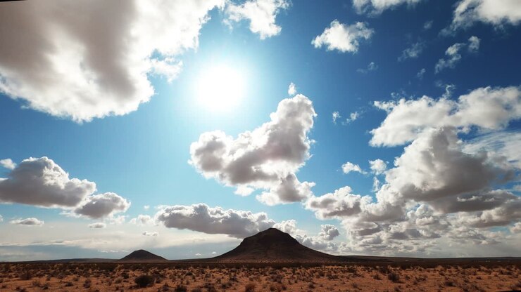 Formazioni nuvolose sopra la splendida terra arida del deserto del Mojave in una luminosa giornata di sole - Time lapse.