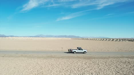 a drone follow shot of a truck along a quiet highway in central usa with simple power lines